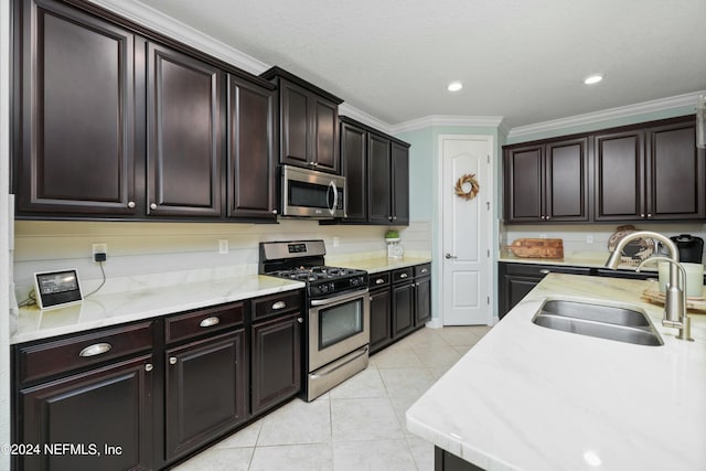 kitchen with sink, ornamental molding, light tile patterned floors, dark brown cabinetry, and stainless steel appliances