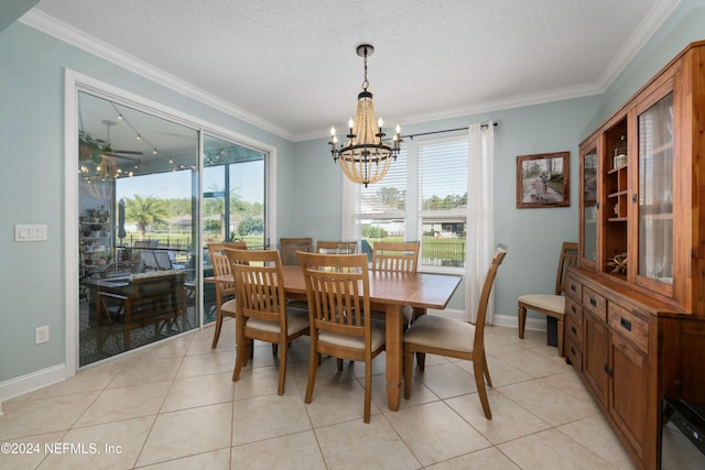 dining space with a chandelier, light tile patterned floors, a textured ceiling, and ornamental molding