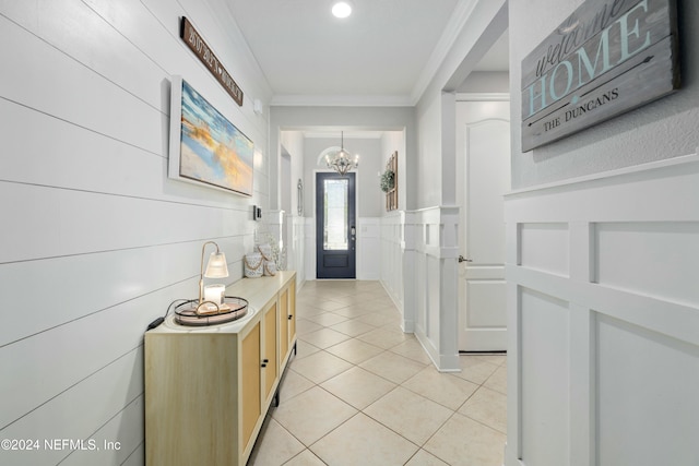 interior space with light tile patterned floors, crown molding, and a chandelier