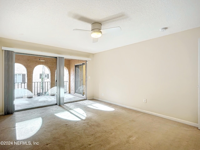 empty room with a textured ceiling, ceiling fan, and light carpet