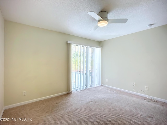 carpeted spare room featuring ceiling fan and a textured ceiling