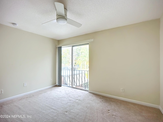 spare room featuring a textured ceiling, light colored carpet, and ceiling fan