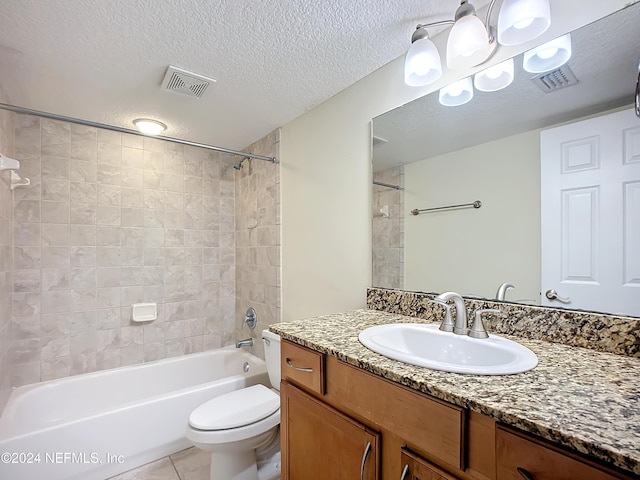 full bathroom with vanity, tiled shower / bath, tile patterned flooring, toilet, and a textured ceiling