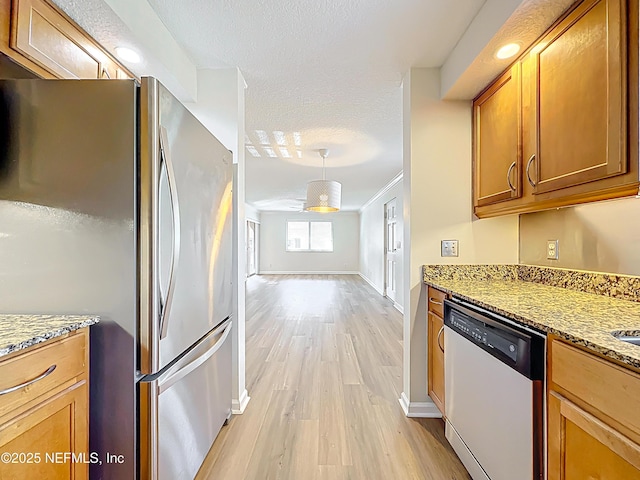 5375 Ortega Farms Blvd Unit 614, Jacksonville, FL 32210 - kitchen with freestanding refrigerator, dishwashing machine, light wood-style floors, brown cabinetry, and light stone countertops