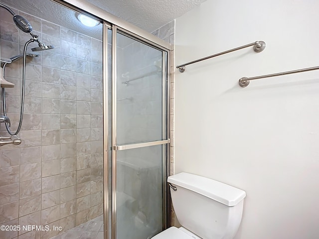 5375 Ortega Farms Blvd Unit 614, Jacksonville, FL 32210 - bathroom with a textured ceiling, a shower stall, and toilet