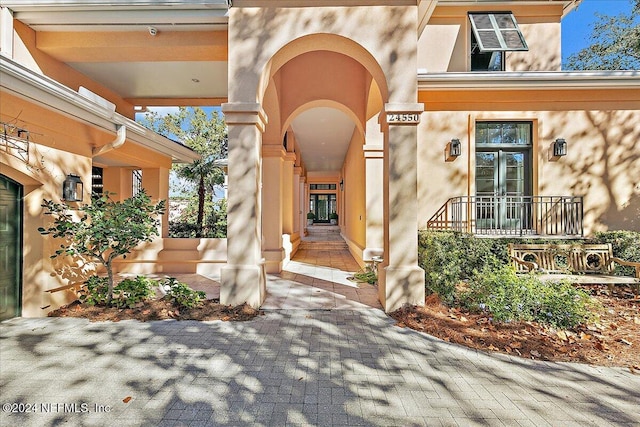 entrance to property with stucco siding and covered porch