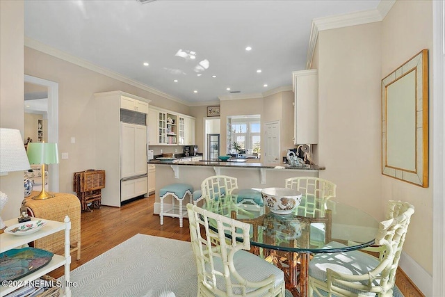 dining area with crown molding, recessed lighting, wood finished floors, and baseboards