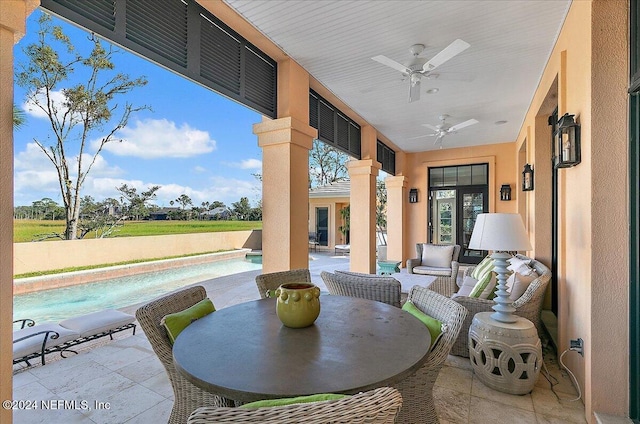 view of patio / terrace with an outdoor pool and a ceiling fan