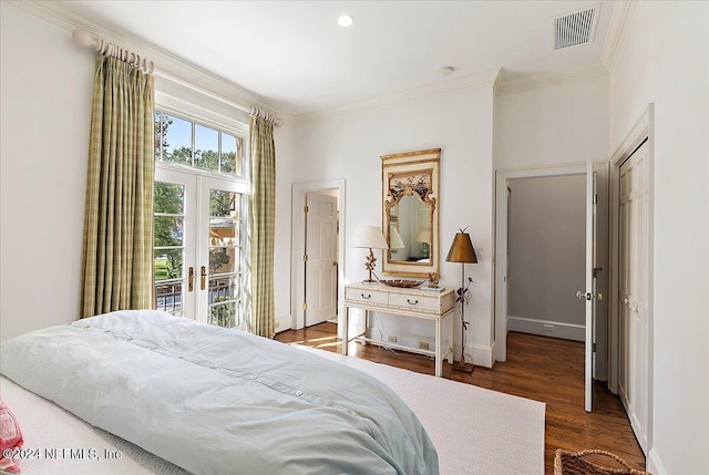 bedroom with visible vents, wood finished floors, crown molding, and french doors