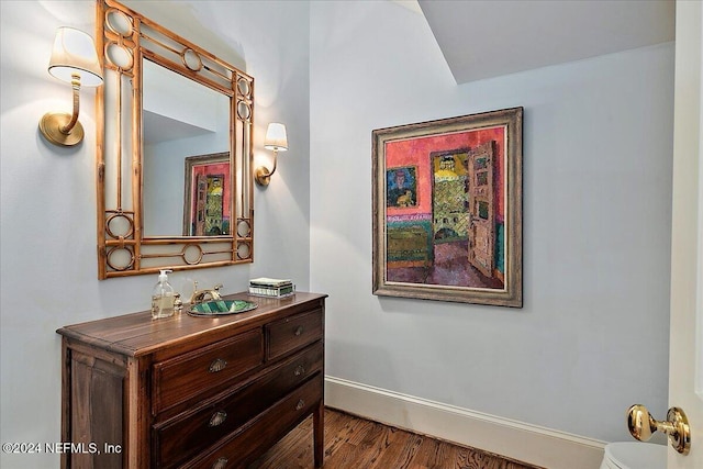 hallway featuring baseboards and wood finished floors