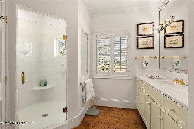 bathroom with wood finished floors, plenty of natural light, ornamental molding, and a shower stall