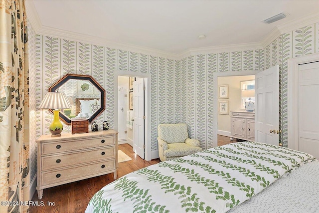 bedroom featuring wallpapered walls, crown molding, dark wood finished floors, and visible vents