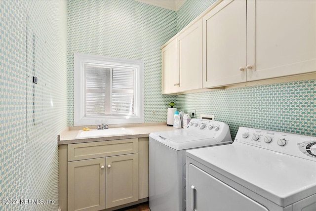 washroom with washer and clothes dryer, cabinet space, and a sink