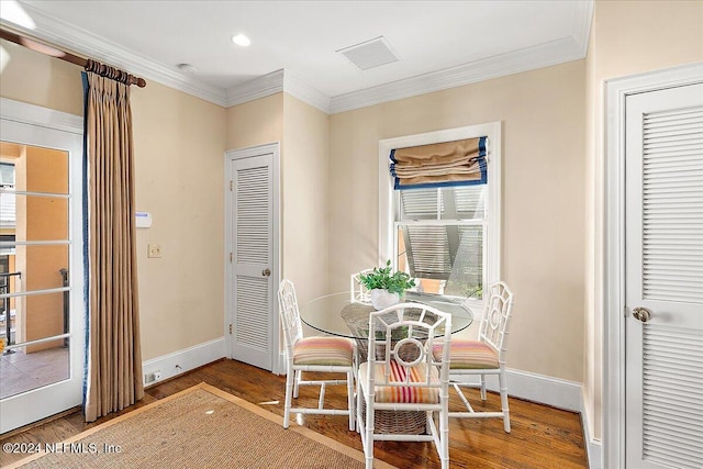 dining area with ornamental molding, baseboards, and wood finished floors