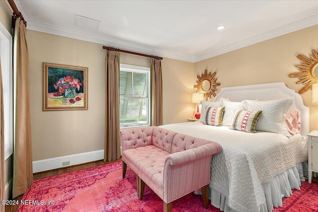 bedroom with wood finished floors, baseboards, and ornamental molding