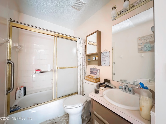 full bathroom featuring toilet, combined bath / shower with glass door, a textured ceiling, and vanity