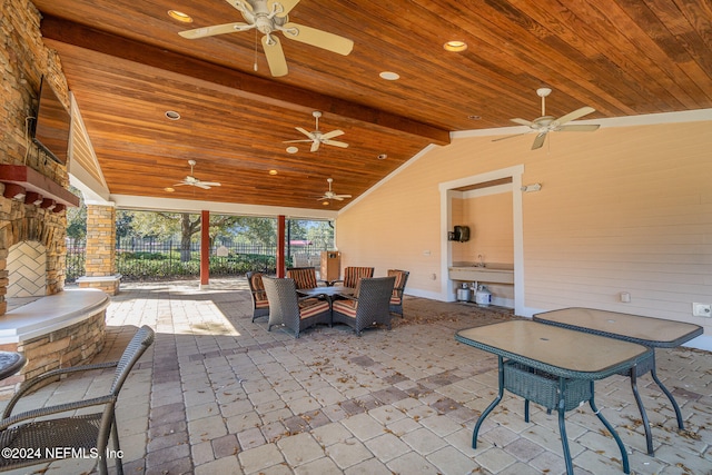 view of patio / terrace with ceiling fan and an outdoor stone fireplace