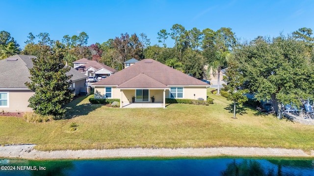 back of house featuring a lawn, a patio area, and a water view