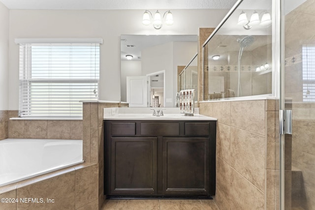 bathroom featuring vanity and independent shower and bath