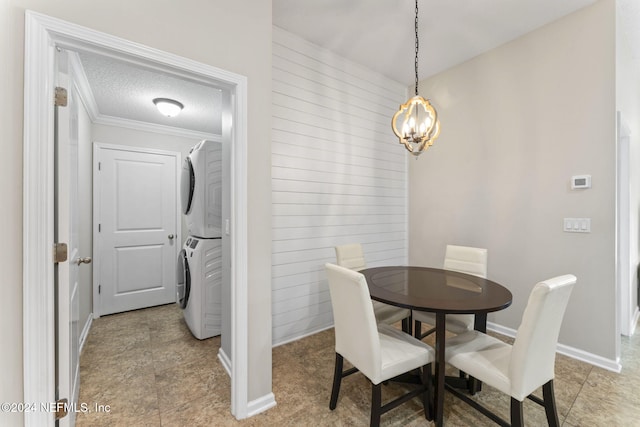 dining space with crown molding, stacked washing maching and dryer, and a textured ceiling