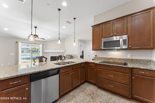 kitchen featuring light stone countertops, ceiling fan, stainless steel appliances, pendant lighting, and a textured ceiling