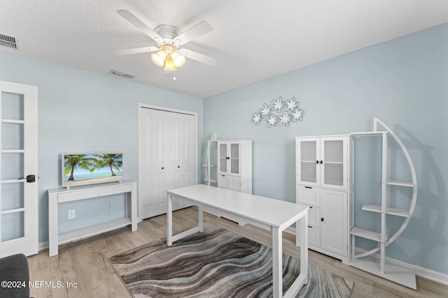 office space with a textured ceiling, light hardwood / wood-style floors, and ceiling fan