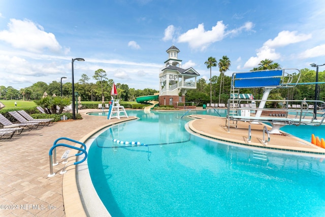 view of swimming pool with a patio and a water slide