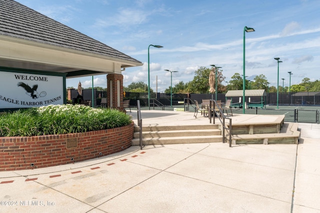 view of community featuring tennis court