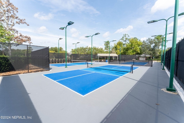 view of tennis court featuring basketball hoop