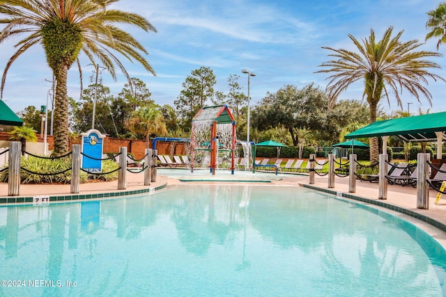 view of swimming pool with a playground