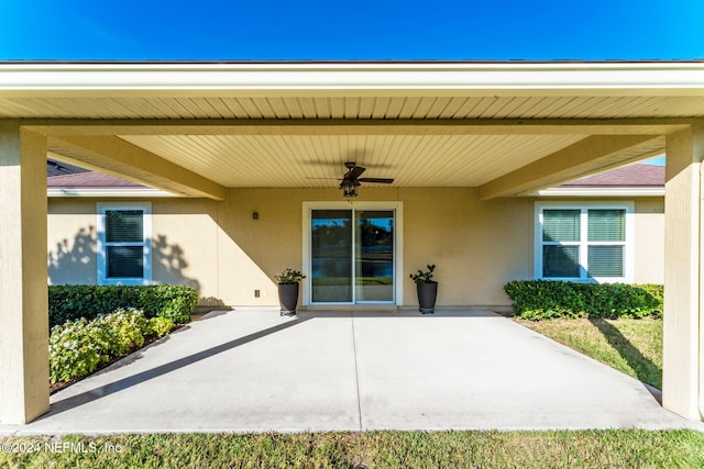 entrance to property with a patio area and ceiling fan