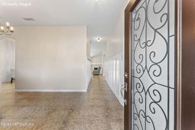 hallway with an inviting chandelier