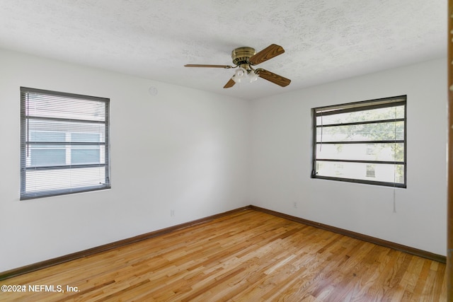 spare room with ceiling fan, light wood-type flooring, and a textured ceiling