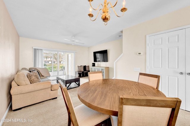 dining space featuring ceiling fan with notable chandelier and carpet floors