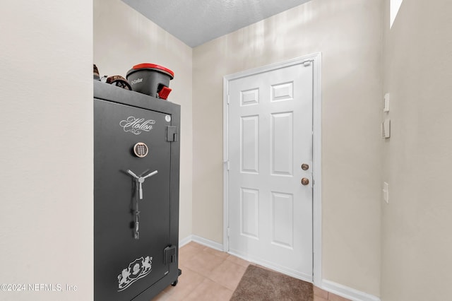 entrance foyer with a textured ceiling and light tile patterned flooring