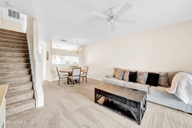 living room with carpet flooring and ceiling fan with notable chandelier