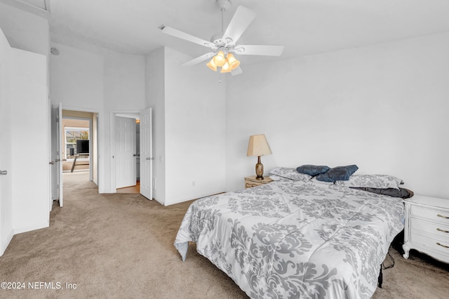 carpeted bedroom with a high ceiling and ceiling fan