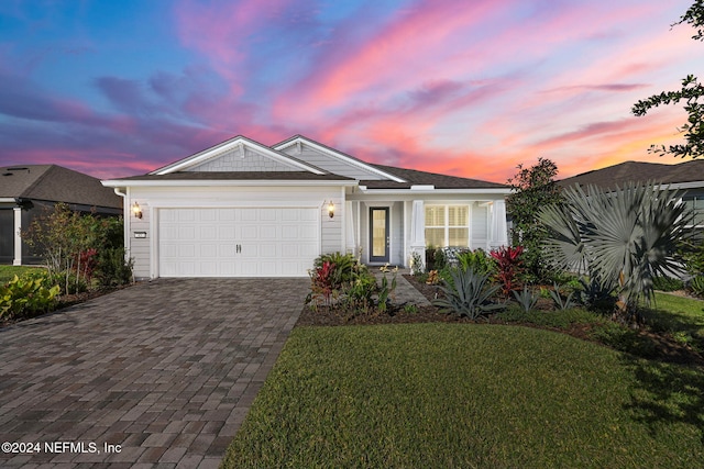 view of front of property featuring a lawn and a garage