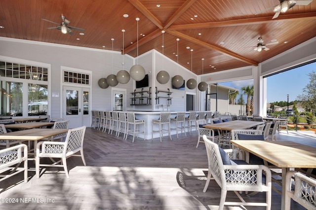 wooden deck featuring ceiling fan and exterior bar