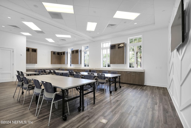 dining area featuring a paneled ceiling and dark wood-type flooring