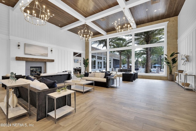 living room featuring beam ceiling, a high ceiling, a chandelier, light hardwood / wood-style floors, and wood ceiling