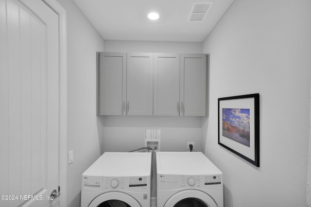 laundry area featuring washer and dryer and cabinets