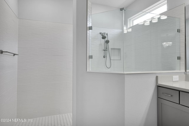 bathroom with vanity and tiled shower