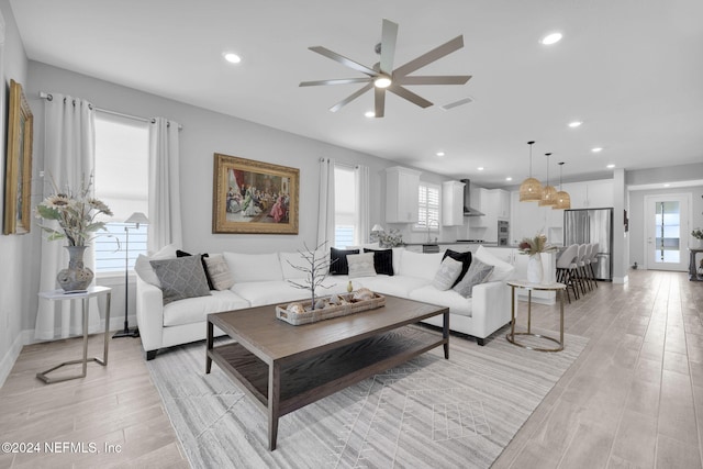 living room with light hardwood / wood-style flooring and ceiling fan