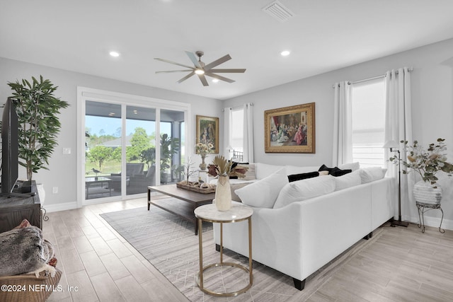 living room featuring ceiling fan, a healthy amount of sunlight, and light hardwood / wood-style floors