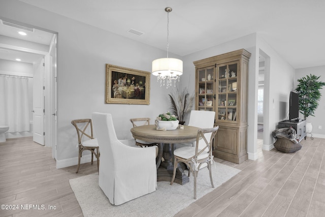 dining area featuring a chandelier and light hardwood / wood-style flooring