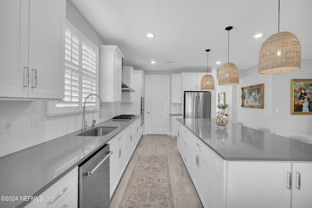 kitchen featuring sink, light hardwood / wood-style flooring, a large island, white cabinetry, and stainless steel appliances