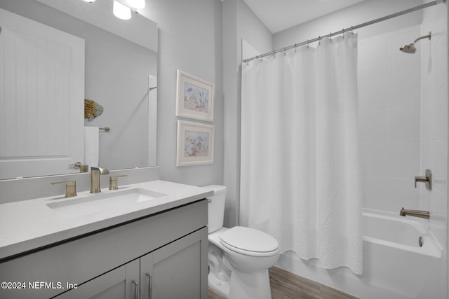 full bathroom featuring hardwood / wood-style flooring, shower / bath combination with curtain, toilet, and vanity