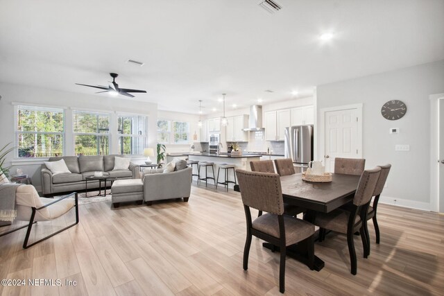 dining area with a wealth of natural light, ceiling fan, and light wood-type flooring