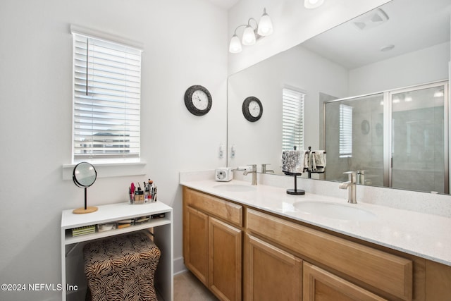 bathroom with vanity, a healthy amount of sunlight, and an enclosed shower